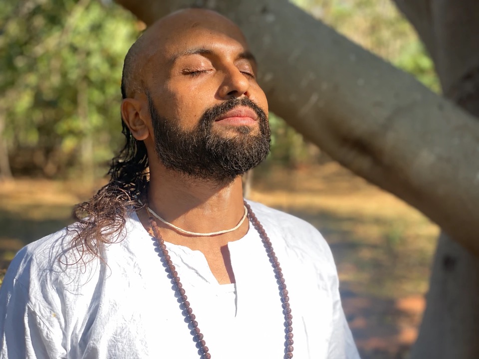Anup meditating in warm sunlight, eyes closed