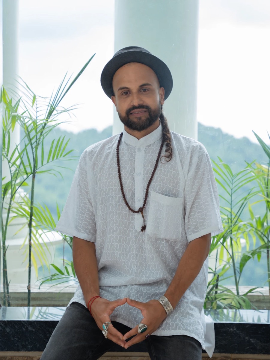 Portrait of Anup smiling, mountains behind