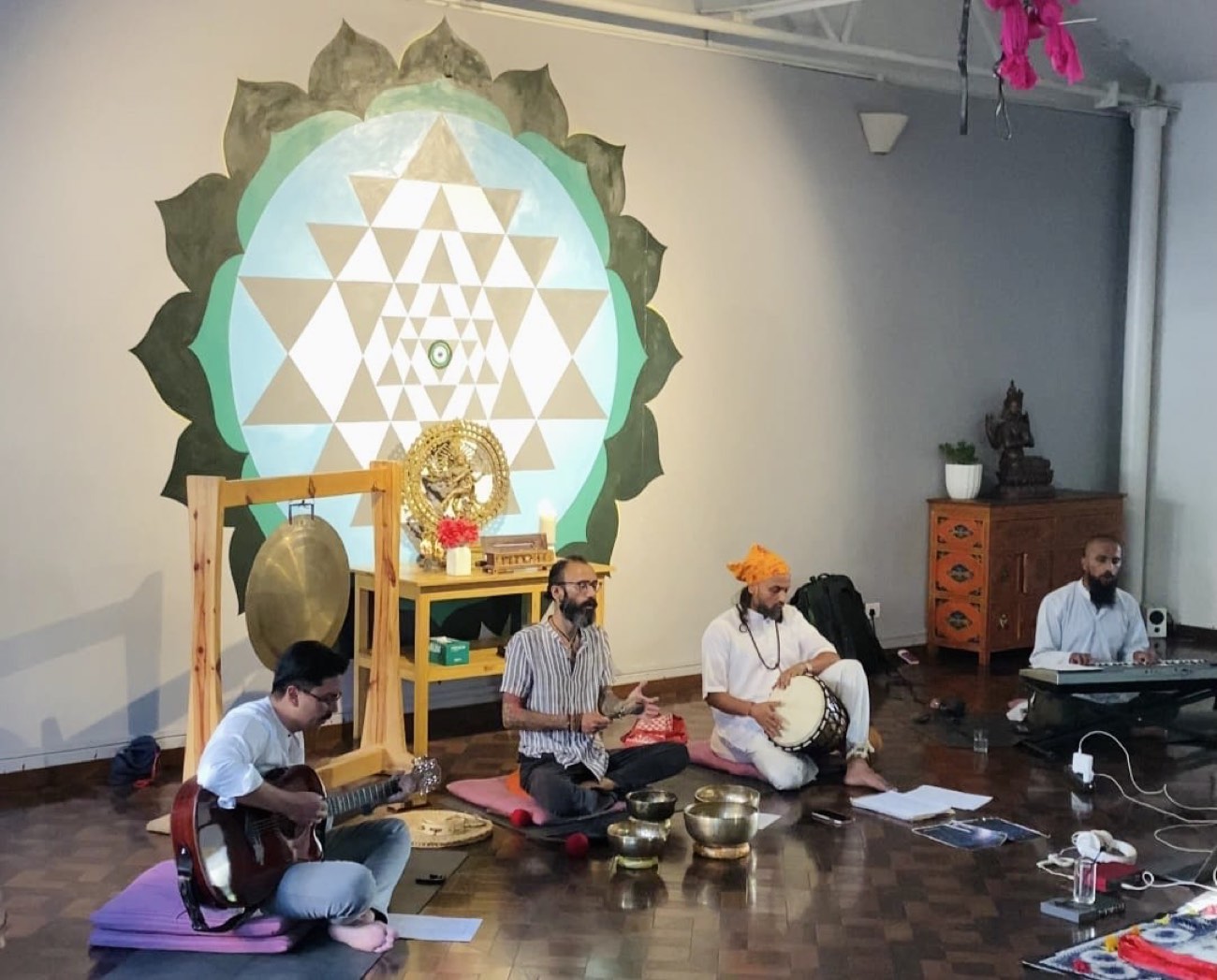 Musicians playing guitar, singing bowls and drum for a group meditation